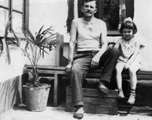 Петр Езеров под окном своего дома с внучкой Ларисой. Около 1965 г.